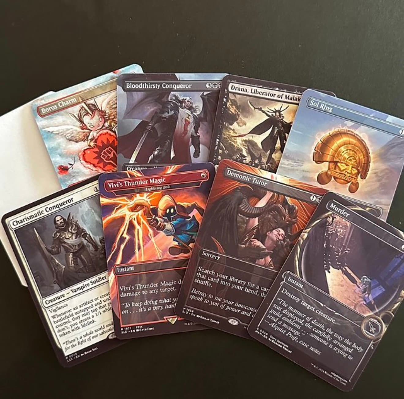 A fan of Magic: The Gathering cards featuring diverse fantasy art on a dark background.